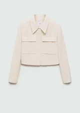 Chaqueta corta de diseño recto con cuello camisero y cierre frontal de botones ocultos. Presenta un estampado de rayas verticales finas, dos bolsillos de parche en la parte delantera y manga larga.