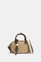 Bolso pequeño tipo bowling de rafia tejida en color natural, con ribetes, asas de mano y detalles en cuero marrón oscuro. Incluye un charm colgante con candado dorado y una correa ajustable extraíble para llevar al hombro o cruzado.
