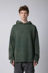 Buzo canguro de corte oversize en color verde con efecto de teñido desgastado. Cuenta con capucha, bolsillo frontal tipo canguro y puños acanalados.