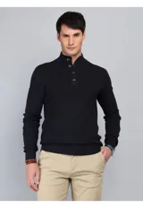 Sweater de punto color azul marino, con cuello alto y cierre frontal parcial de botones. Presenta puños y ruedo acanalados.