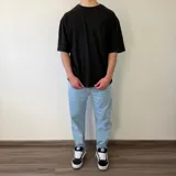 Remera gris con efecto acid wash, corte oversize y diseño holgado, con gran aplique bordado en la espalda.