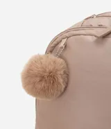 Mochila femenina color beige con textura acolchada y bolsillo frontal con cierre. Incluye asas largas ajustables, correa de mano y llavero de pompón.