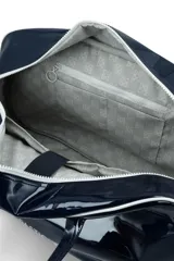 Bolso de fin de semana tipo duffle, confeccionado en material sintético efecto charol color marrón oscuro. Cuenta con doble asa superior, correa ajustable extraíble, cierre principal y logo de la marca estampado en el frente.