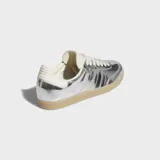 Championes Adidas Samba OG en acabado plateado metalizado, con detalles en color crema y suela de goma marrón translúcida.