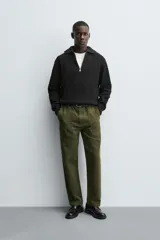 Jersey negro de punto perlado con cuello perkins y cierre frontal de cremallera.