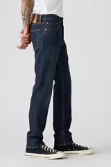 Jean de corte slim fit, color azul oscuro con efecto lavado sutil. Presenta cierre de botones y cinco bolsillos clásicos.