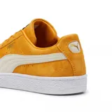 Championes Puma Suede Classic color mostaza con franja lateral blanca y suela blanca.