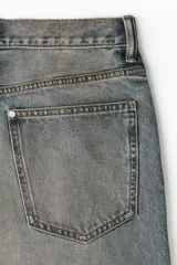 Jean de corte baggy en denim de algodón rígido, color azul con efecto deslavado y acabado vintage. Diseño de cinco bolsillos, tiro bajo y piernas amplias redondeadas.