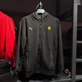 Campera con capucha y cierre frontal, color negro, con logo de Puma en el pecho derecho y escudo de Ferrari en el pecho izquierdo.