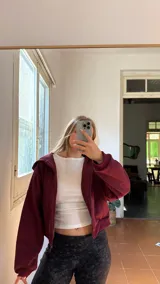 Campera de jogging bordó con cierre frontal completo, capucha y bolsillos laterales. Confeccionada en tela frizada en su interior, ofrece un ajuste cómodo y cálido.