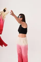 Pantalón sastrero de lino con diseño degradado en tonos beige y rosado, de tiro medio-alto, corte flared y pinzas en la cintura. Cuenta con bolsillos laterales y cierre con trabilla metálica.