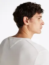 Sweater de cuello redondo color crema de algodón, con logo bordado en el pecho.