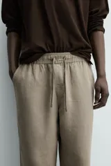 Pantalón de corte regular fit confeccionado en tejido mezcla de algodón, con cintura elástica ajustable mediante cordón, bolsillos laterales y bolsillos traseros de vivo.