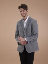 Blazer formal color negro, confeccionado en tela texturada, con solapas clásicas, cierre de dos botones frontales y bolsillos con solapa.
