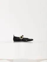 Ballerinas negras charoladas con tira sobre el empeine y hebilla dorada.