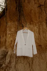 Blazer color crudo confeccionado en lino italiano. De corte relajado, con un único botón frontal y simulación de bolsillos.