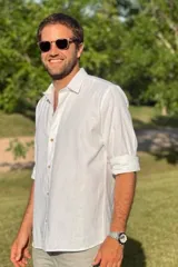 Camisa blanca de lino con cuello clásico, mangas largas con puños abotonados y cierre frontal con botones de madera.