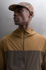Chaqueta cortavientos Zara Athleticz de diseño bicolor en tonos marrón y tostado, con capucha, cierre frontal de cremallera y bolsillos funcionales.