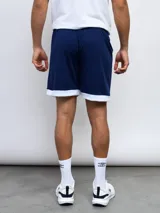 Short deportivo Umbro azul marino con cintura elástica y ribete blanco en el ruedo.