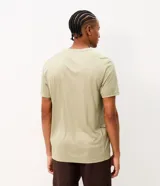 Remera deportiva de hombre Get Over con tecnología dry, color beige, de corte regular, cuello redondo y manga corta. Presenta detalles reflectantes en los hombros y tejido texturizado.
