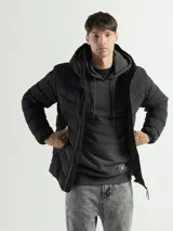 Campera acolchada de nylon color negro, con diseño de canales horizontales, capucha integrada y cierre frontal. Cuenta con puños y ruedo elásticos para mayor ajuste y bolsillos laterales con cierre.