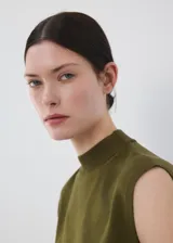 Chaleco de punto fino color verde militar, con diseño recto, cuello perkins, manga corta y detalle de cinturón para atar en la cintura.