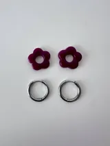 Aros de acero quirúrgico argolla con dije colgante en forma de flor de resina color gris marmoleado.