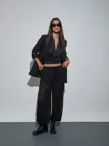 Pantalón negro de encaje con transparencias, tiro medio y cintura elástica ajustable con cordón.