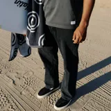 Pantalón de jean negro de corte recto y relajado, estilo clásico de 5 bolsillos, tiro medio y abertura de pierna de 18 pulgadas.