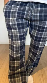 Pantalón de hombre confeccionado en franela a cuadros grises y marrones, con elástico en la cintura y dos bolsillos laterales.