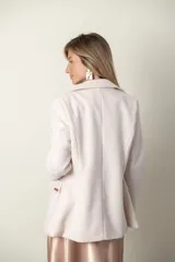 Blazer verde con corte clásico, doble botonadura y bolsillos con solapa.