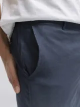 Pantalon de corte clasico confeccionado en una mezcla de lino y viscosa. Presenta cintura con pasadores para cinturon, cierre y boton frontal, dos bolsillos laterales y dos bolsillos traseros con boton.