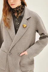 Tapado negro de corte recto y largo medio, con solapas clásicas, cierre frontal de un botón y bolsillos laterales amplios.