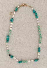 Collar de diseño artesanal que combina piedras naturales en tonos verdes y turquesas con perlas irregulares y pequeñas cuentas doradas.
