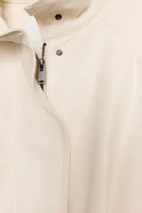 Chaqueta bomber oversize de efecto piel en color crema, con cuello subido, manga larga con hombro caído y cintura con frunces y cinturón ajustable con hebilla metálica. Cuenta con cierre frontal oculto y bolsillos laterales de vivo.