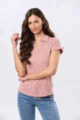 Remera polo de algodón color beige con mangas cortas, escote en V y cuello camisero. Presenta delicados mini bordados florales distribuidos en toda la prenda.