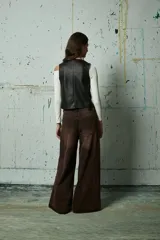 Jean de corte wide leg en color gris lavado, con diseño de aberturas laterales decoradas con tachas metálicas a lo largo de toda la pierna.