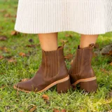 Botas tipo chelsea de cuero vacuno negro, con elásticos laterales, taco cuadrado y punta fina.