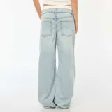 Pantalón jean celeste de corte ancho, tiro alto y efecto calzoncillo a la vista.