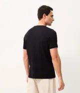Remera de algodón peruano color beige con textura de rayas verticales, cuello redondo y mangas cortas.