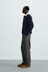 Sudadera de manga larga estilo polo con diseño de rayas horizontales anchas en azul marino y blanco. Presenta cuello de solapa en contraste, cierre frontal con botones ocultos y acabados en rib en puños y bajo.