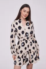 Vestido corto con estampado animal print en tonos beige, negro y azul. Tiene cuello mao, mangas largas con puños elásticos, cintura elastizada y falda con volantes.