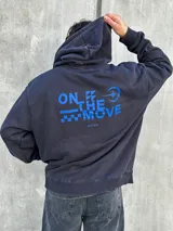 Canguro negro con capucha ajustable con cordones, bolsillo tipo canguro y logo bordado en azul en el pecho.