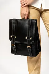 Mochila color crema con correas ajustables, hebillas decorativas y cierre con solapa.