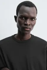 Camiseta de manga larga con corte relajado, confeccionada en tejido compacto de algodón. Presenta cuello redondo acabado en rib y detalle de costura central en la espalda.