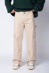 Pantalón tipo carpintero de corte relaxed fit y tiro medio, confeccionado en denim negro con costuras a contracolor en blanco. Presenta múltiples bolsillos cargo laterales, un bolsillo con cierre en la parte inferior y presillas utilitarias.