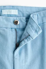 Jean acampanado de denim suave en color celeste, con tiro alto, cierre frontal con botón y bolsillos traseros.