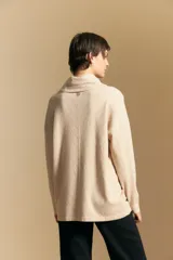 Polera de tejido de punto color naranja con cuello alto de caída relajada y diseño de líneas en relieve. Presenta una silueta holgada con hombros caídos y mangas largas.