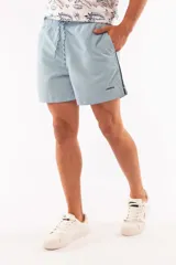 Short de baño azul con cintura elástica y cordón ajustable. Tiene dos bolsillos laterales y un bolsillo trasero.