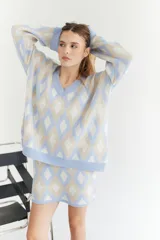 Sweater de lana artesanal con diseño de rombos en tonos celeste, beige y blanco. Corte oversize con mangas amplias y cuello en V.